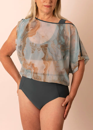 Mature woman wearing a one piece swim suit with blue marble printed top & sold grey-blue bottom
