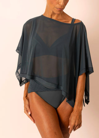 Mature woman wearing a sheer flowy blue grey top and matching swimsuit