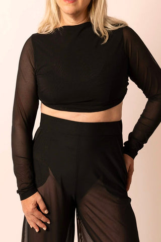 Reversible black long-sleeve twist top with sheer sleeves worn by a mature woman