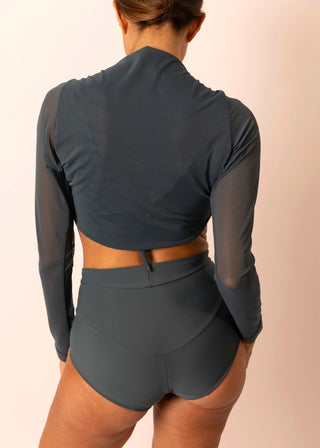Reversible blue grey long-sleeve twist top with sheer sleeves worn by a mature woman