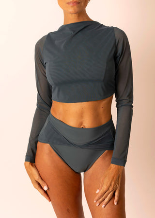 Reversible blue grey long-sleeve twist top with sheer sleeves worn by a mature woman