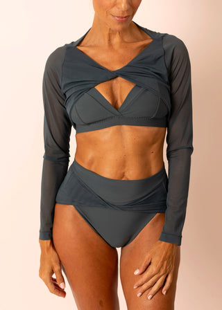 Reversible blue grey long-sleeve twist top with sheer sleeves worn by a mature woman