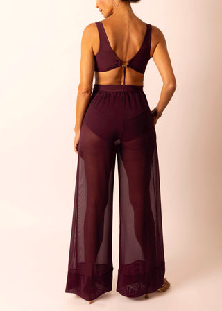 Mature woman wearing sheer burgundy wide leg pant and matching swim top