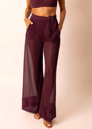 Mature woman wearing sheer burgundy wide leg pant and matching swim top