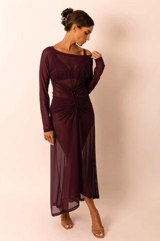 Mature woman wearing a long solid burgundy mesh dress with long sleeves