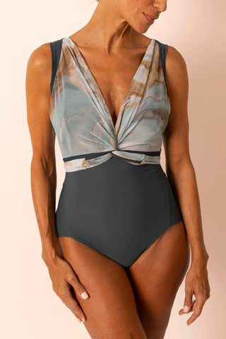 Mature woman wearing a light teal & tan marble printed wrap top one piece swimsuit with matching custom swim top